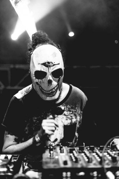 戴着骷髅面具的DJ在夏季派对上演奏电子音乐。乐趣，青春，娱乐和节日的概念。图片下载