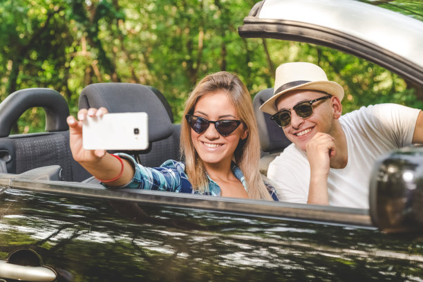 美丽的夫妇从他们的敞篷车在自然中自画像。图片下载