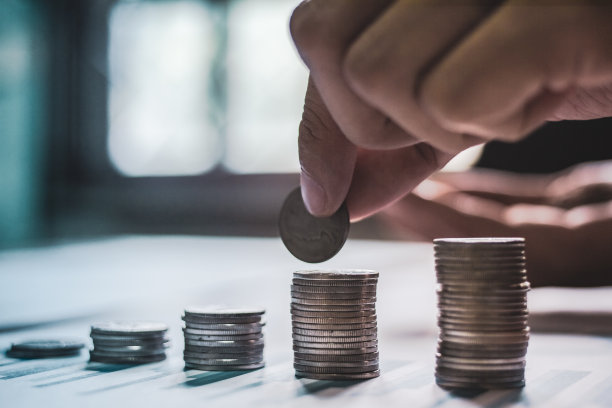 处理硬币放在一堆钱在桌子上与光日落的商业理念。和instagram风格滤镜照片复古色调图片下载