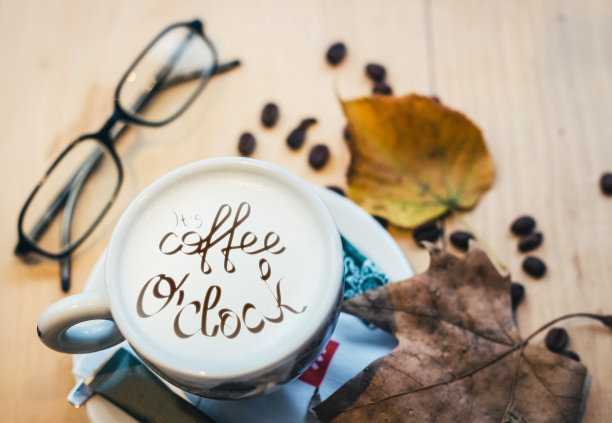 咖啡杯和咖啡豆放在木桌上图片下载