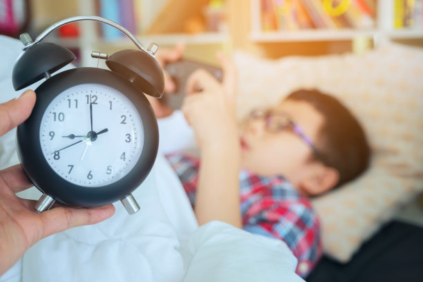 早上拿出手拿闹钟，男孩躺在床上玩手机游戏图片下载