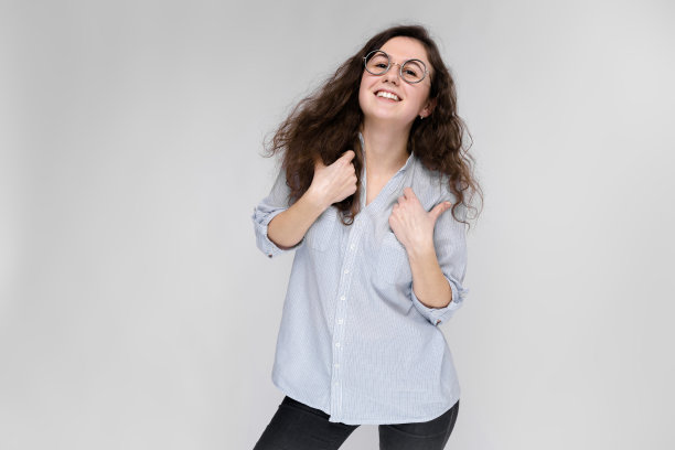 年轻的黑发女孩戴着眼镜。那个女孩出示了班级标志。图片下载