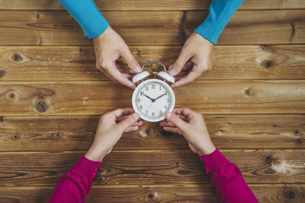 男人和女人都把手表放在木头桌子上图片下载