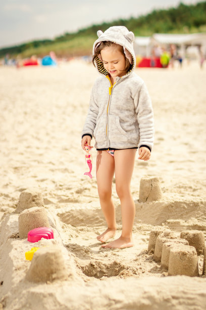 小女孩在沙滩上玩洋娃娃图片下载