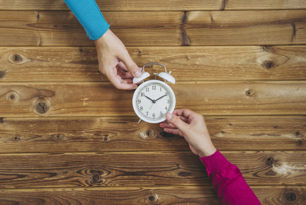 男人和女人都把手表放在木头桌子上图片下载