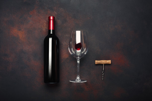 瓶子的葡萄酒，开瓶器和葡萄酒杯在生锈的背景图片下载