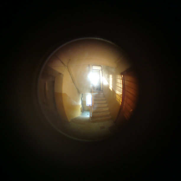门上的眼镜特写。房子走廊里的楼梯。家庭窥视孔的特写图片下载