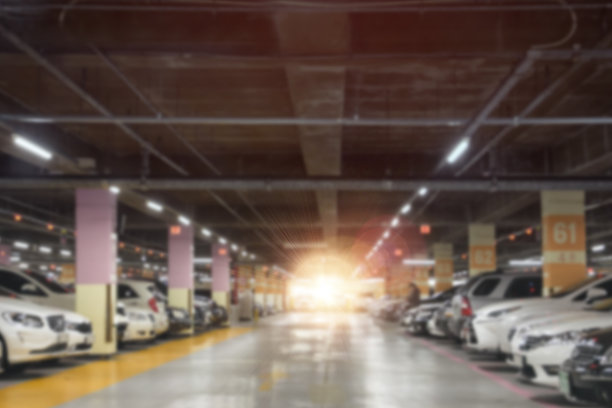 模糊的停车场在购物中心商店与橙色的阳光。图片下载