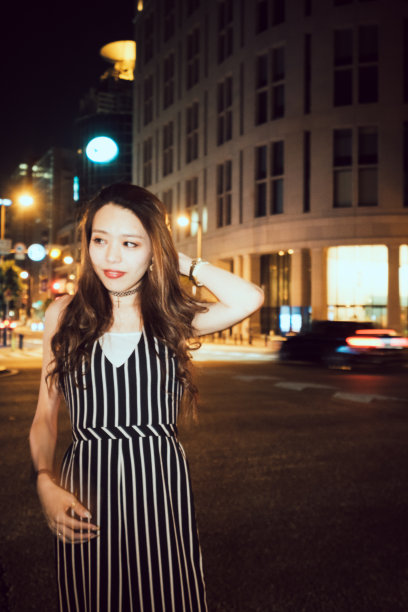 当代年轻的日本妇女在夜晚的街道上的肖像图片下载