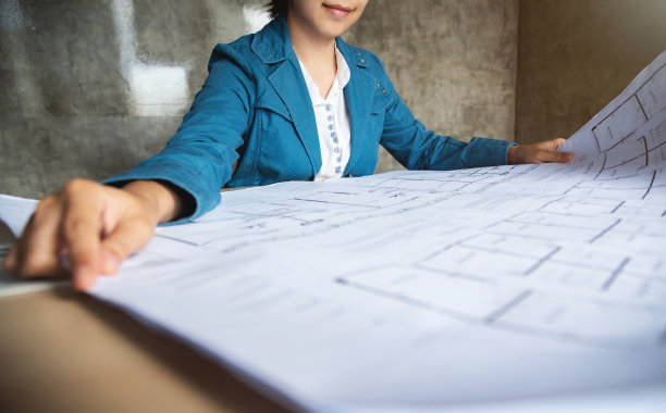 女性看建筑计划蓝图。图片下载