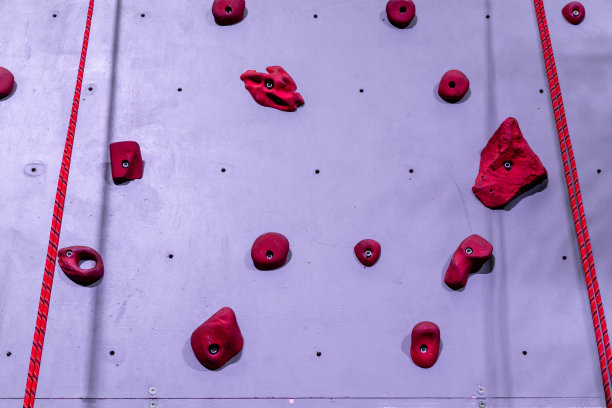 红色和灰色的攀岩墙，带钩和红色的攀岩绳图片下载