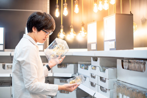 年轻的亚洲人正在仓库里挑选电灯泡的包装图片下载