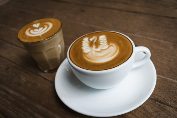 咖啡店的木桌上放着一杯白色的咖啡。图片下载