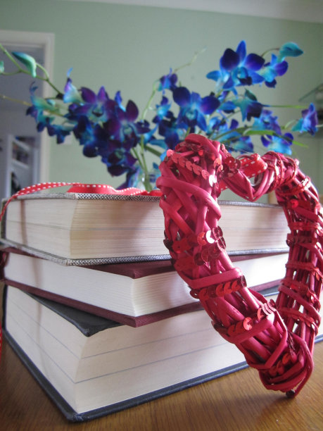 堆着浪漫的红心和蓝色花朵的书图片下载