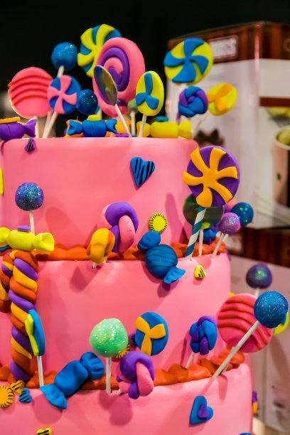 带棒棒糖的粉色分层蛋糕图片下载