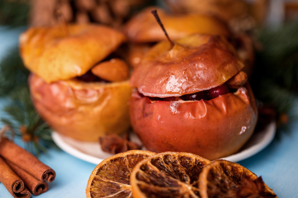 烤苹果和肉桂在乡村背景。秋冬甜点。一个美味的烤苹果与圣诞装饰的特写照片图片下载