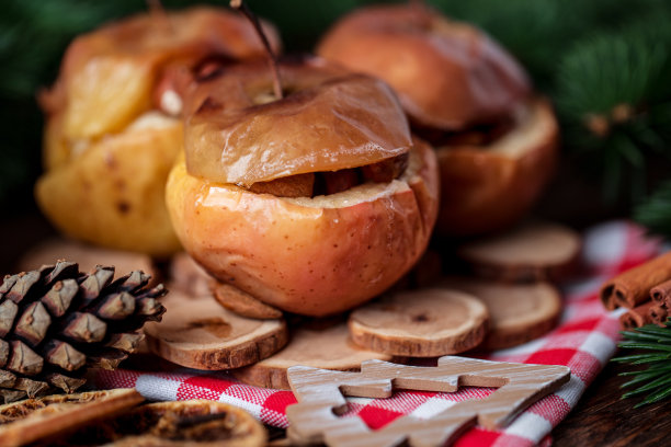 烤苹果和肉桂在乡村背景。秋冬甜点。一个美味的烤苹果与圣诞装饰的特写照片图片下载