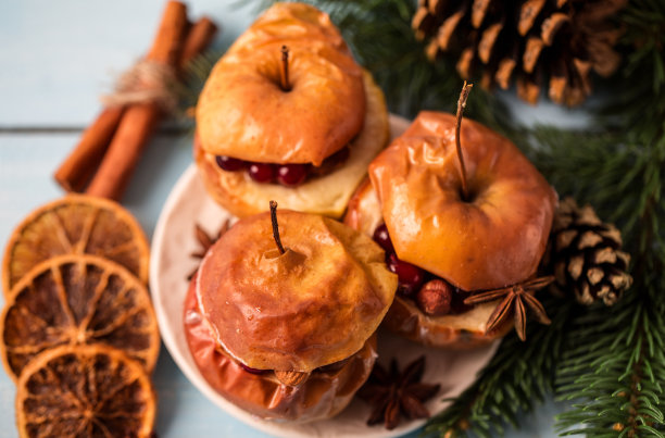 烤苹果和肉桂在乡村背景。秋冬甜点。一个美味的烤苹果与圣诞装饰的特写照片图片下载