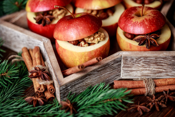 烤苹果和肉桂在乡村背景。秋冬甜点。一个美味的烤苹果与圣诞装饰的特写照片图片下载
