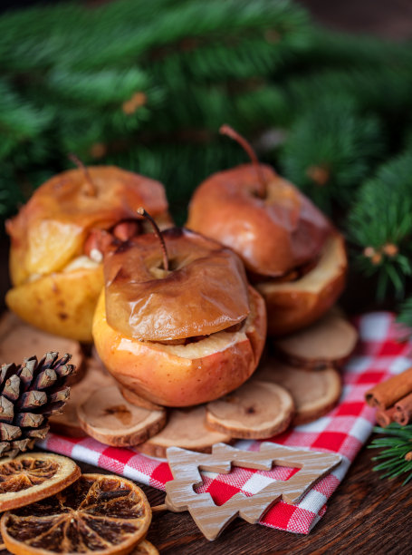 烤苹果和肉桂在乡村背景。秋冬甜点。一个美味的烤苹果与圣诞装饰的特写照片图片下载