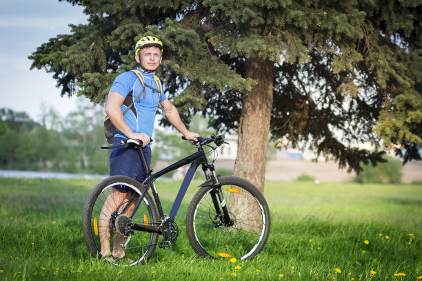 在夏天的公园里骑自行车的人。图片下载