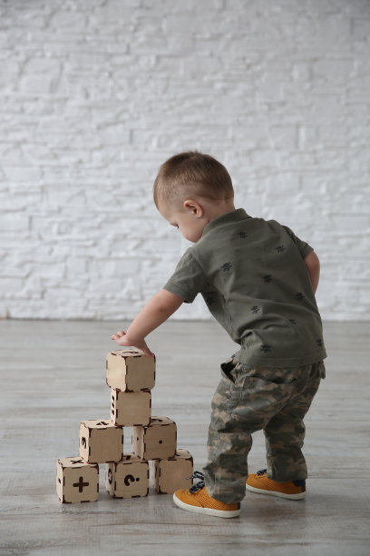 一个小男孩在房间里玩字母玩具积木图片下载