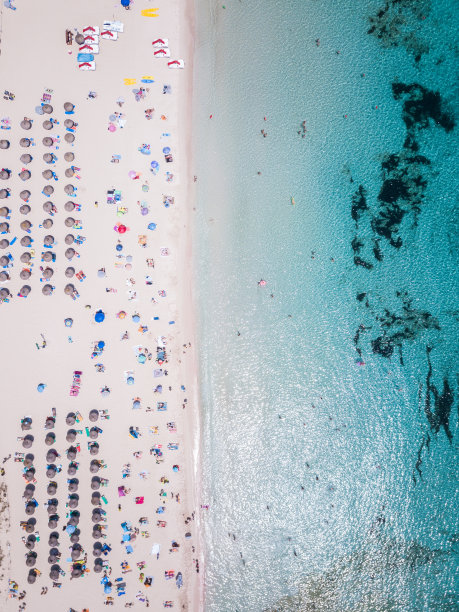 鸟瞰图的海滩伞在美丽的海滩与清澈的蓝色的水。图片下载