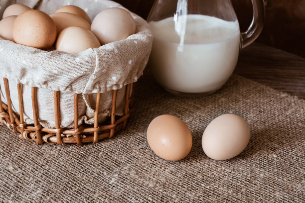 鸡蛋放在篮子里，牛奶横着放。有食物的静物图片下载