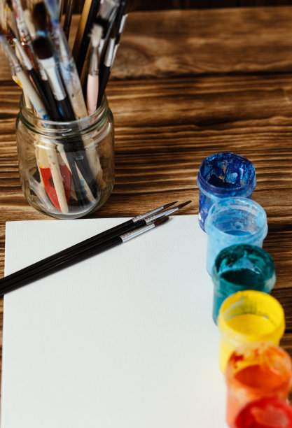 艺术家的工作室。俯视图的画笔调色板和丙烯酸颜料与白色帆布。一套画笔和油画颜料。艺术图片与复制空间和添加文本。儿童创造力项目图片下载