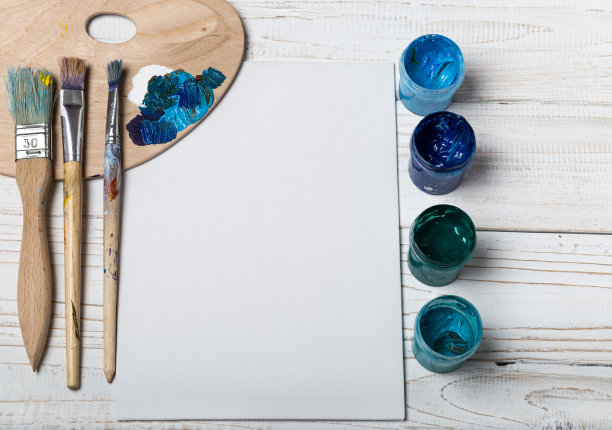 艺术家的工作室。俯视图的画笔调色板和丙烯酸颜料与白色帆布。一套画笔和油画颜料。艺术图片与复制空间和添加文本。儿童创造力项目图片下载