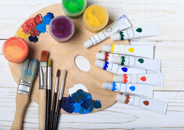 艺术家的工作室。俯视图的画笔调色板和丙烯酸颜料与白色帆布。一套画笔和油画颜料。艺术图片与复制空间和添加文本。儿童创造力项目图片下载
