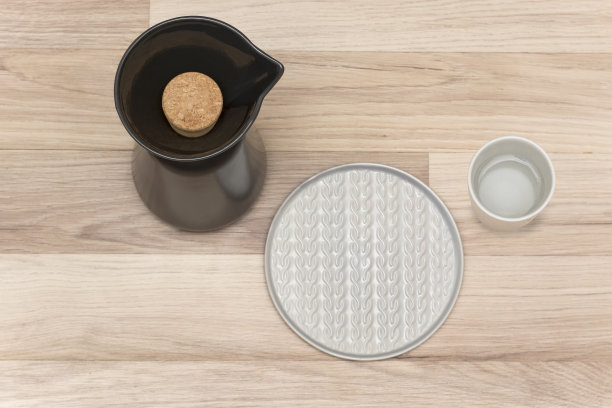 俯视图亚洲风格的瓶子，针织图案灰色板和灰色杯与水静物照片孤立的木制背景与阴影图片下载