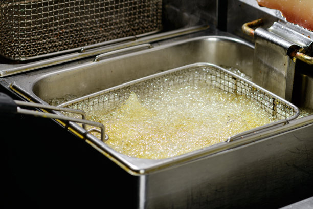 炸薯条烹饪。网格与马铃薯条降低到锅图片下载