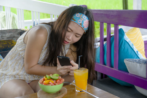 年轻快乐、漂亮的数字游牧亚洲女性用手机拍下水果沙拉的照片，在互联网社交媒体上发布健康营养和旅游博客食物评论图片下载