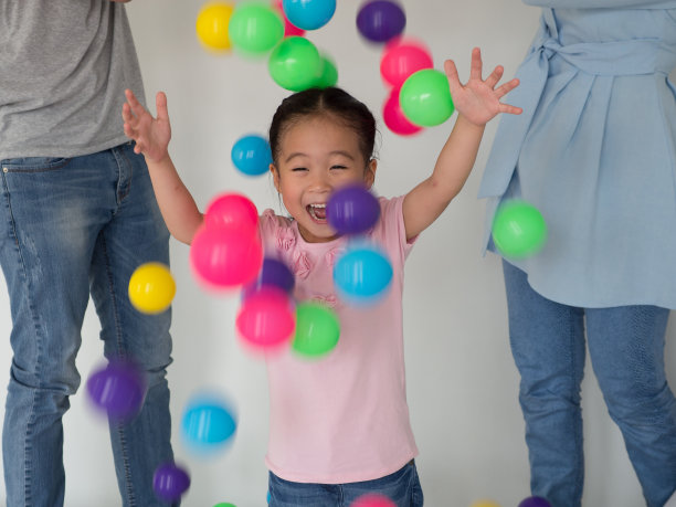 年轻的亚洲孩子玩彩色球。图片下载
