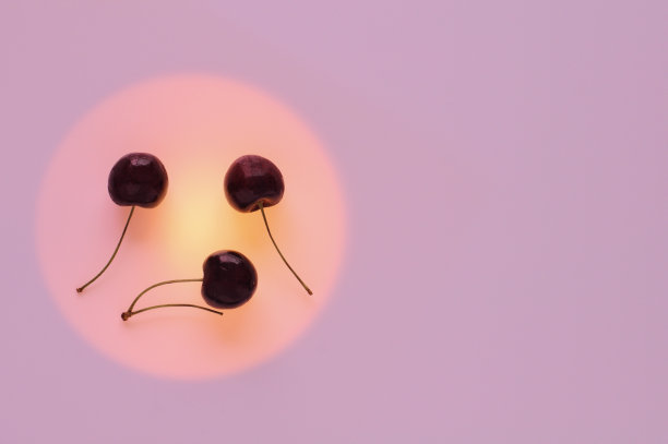 红色的樱桃果把橘红色的圆圈设为悲伤和哭泣的表情图片下载