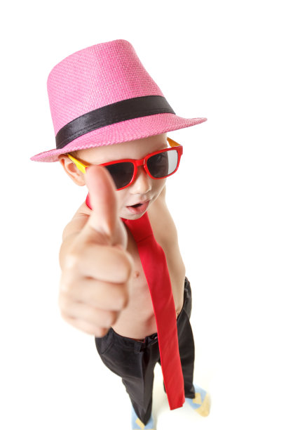 小男孩打着领带，戴着墨镜，戴着帽子在跳舞，孤立在白色上。活泼可爱的小男孩在白色的背景上跳舞。图片下载