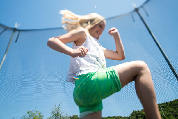 快乐的女孩在蹦床上奔跑图片下载