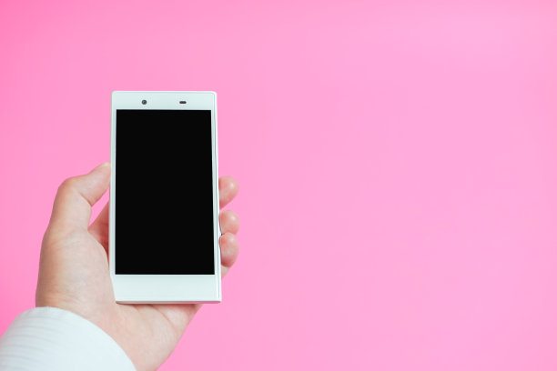 使用智能手机的图像。粉红色的背景。图片下载