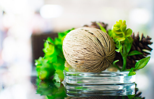 一件当地的装饰品被放置在咖啡馆的玻璃桌上。它是由天然材料制成的。图片下载