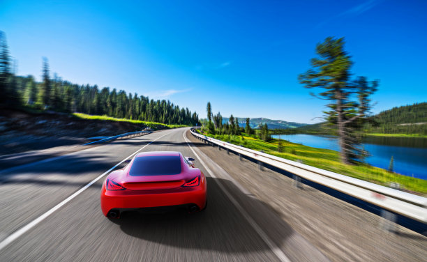 一辆红色的汽车在山路上行驶图片下载