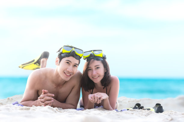 夏天的假期。海滩旅行夫妇有乐趣的浮潜。亚洲微笑夫妇躺在夏天的沙滩上享受潜水设备看图片下载
