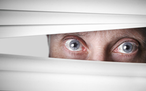 成熟的男人透过百叶窗，睁大眼睛，紧张地看着图片下载