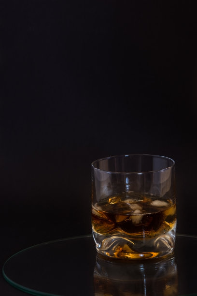 在深色背景上加冰的白兰地图片下载
