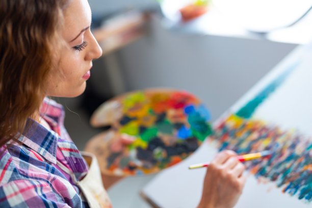 年轻女子坐着画画图片下载