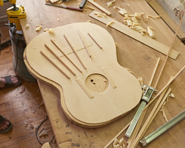在古典吉他的音板上做标记并粘贴支撑。制作古典吉他。图片下载