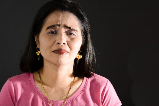 悲伤成熟的成年菲律宾女人在黑色背景下的特写图片下载