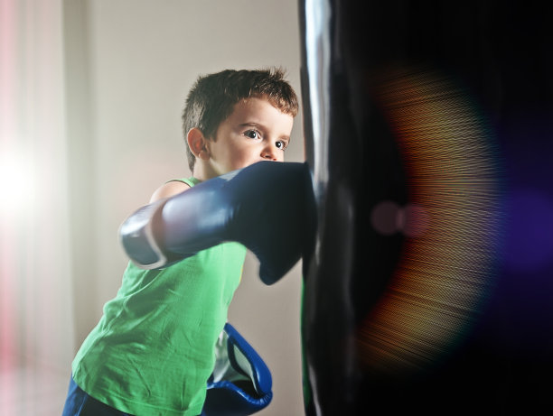 小男孩用沙袋练习拳击图片下载