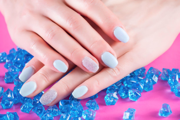 女孩的手上有蓝色的指甲，手上有许多蓝色的水晶或宝石图片下载