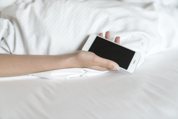 在床上睡觉时拿着手机的女人图片下载